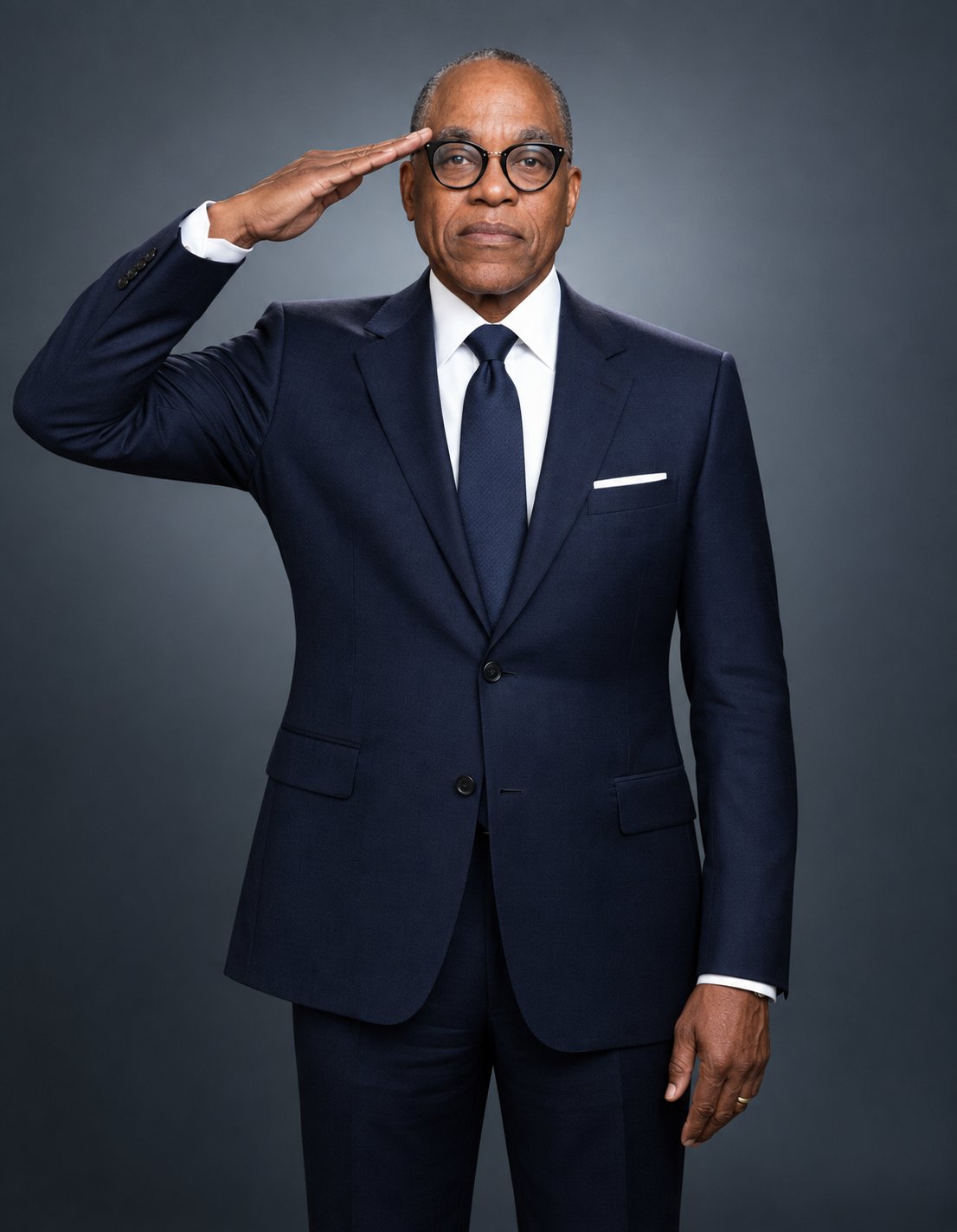 Larry Thomas Brown today in a navy suit, giving a military salute