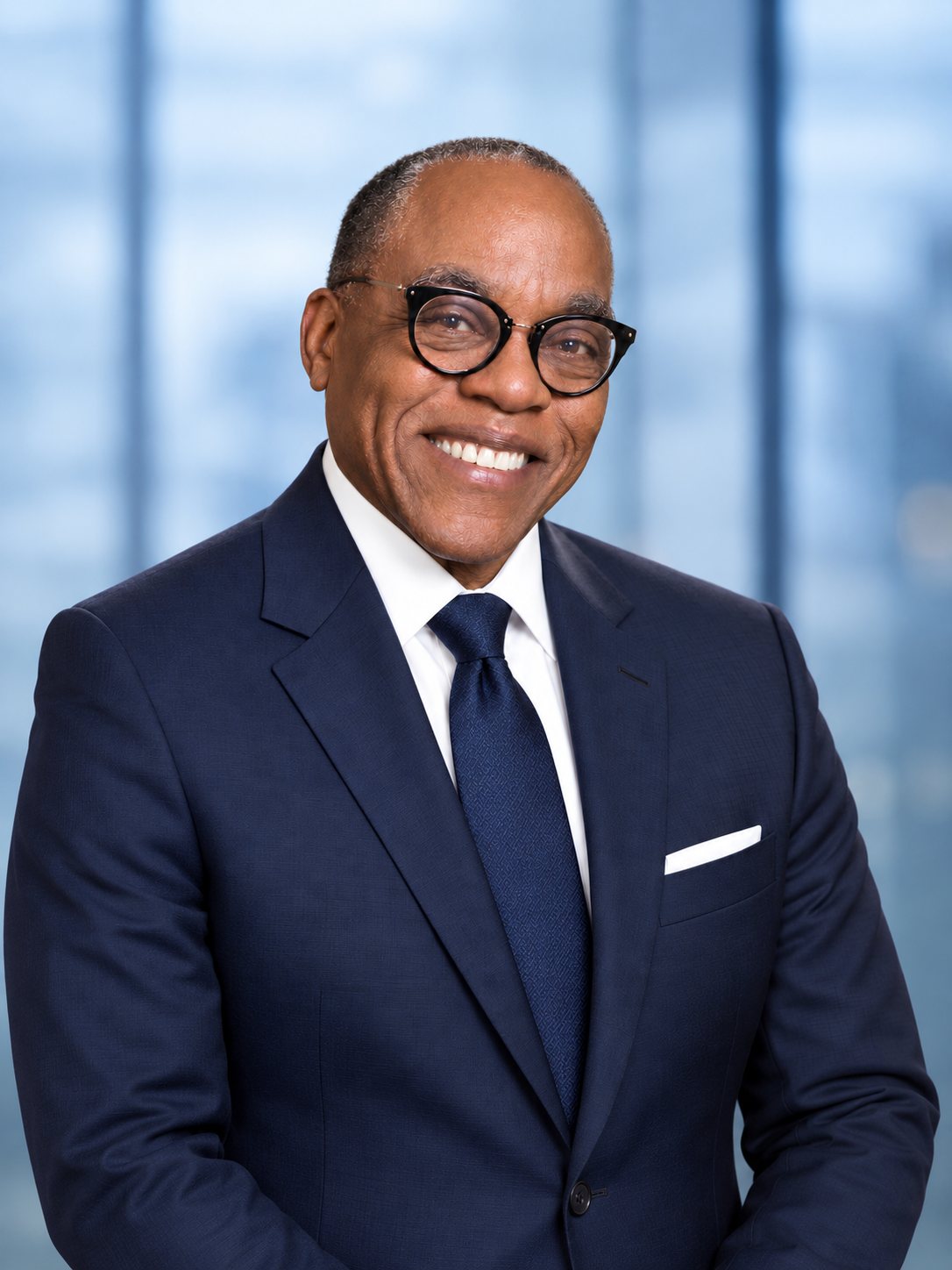 Larry Thomas Brown smiling in front of city windows